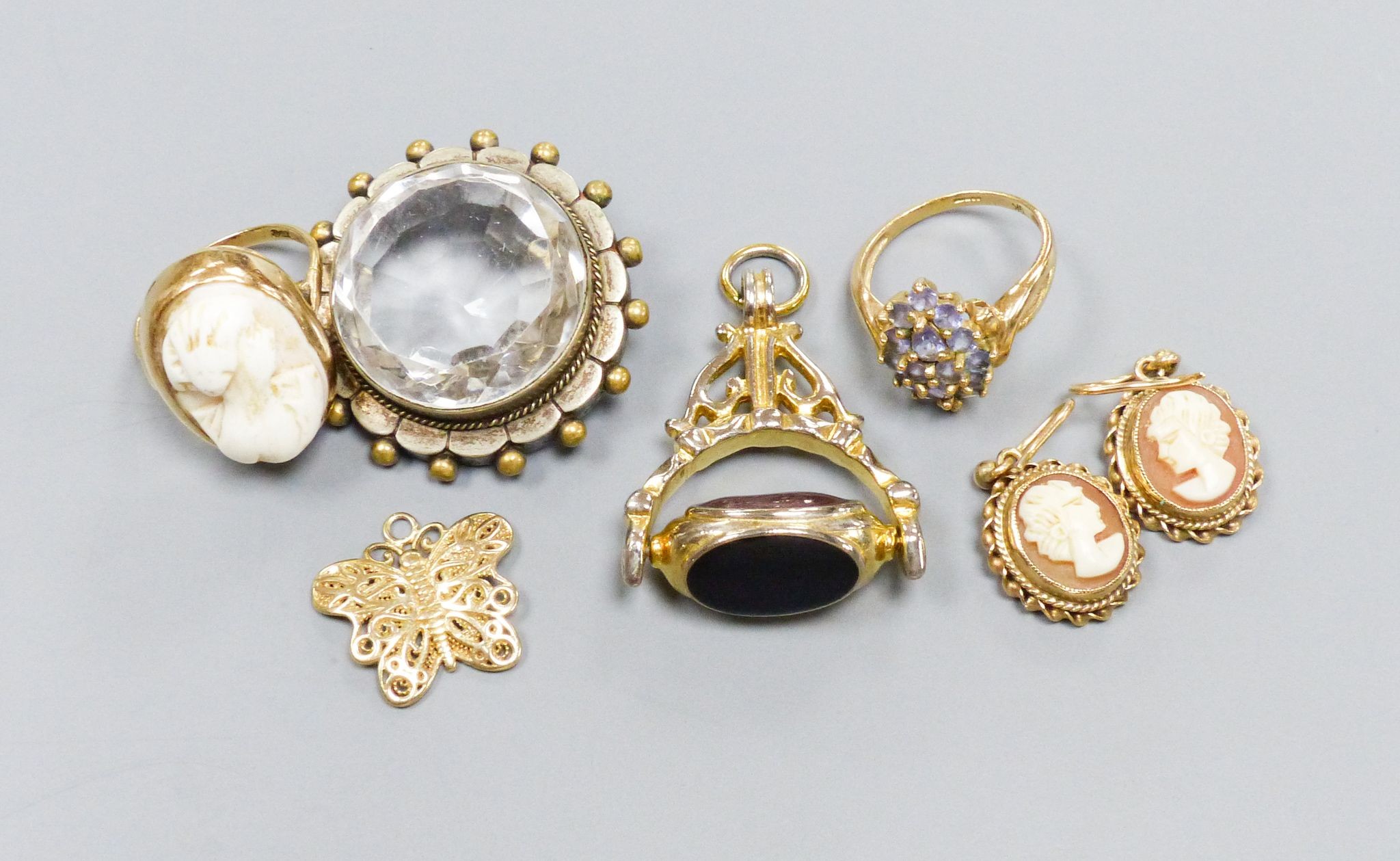 A 9ct gold cameo ring, a pair of similar earrings, yellow metal settings, a 9ct gold gem-set ring, a 'fob seal' pendant, a silver-gilt butterfly pendant and a clear paste-set pendant
